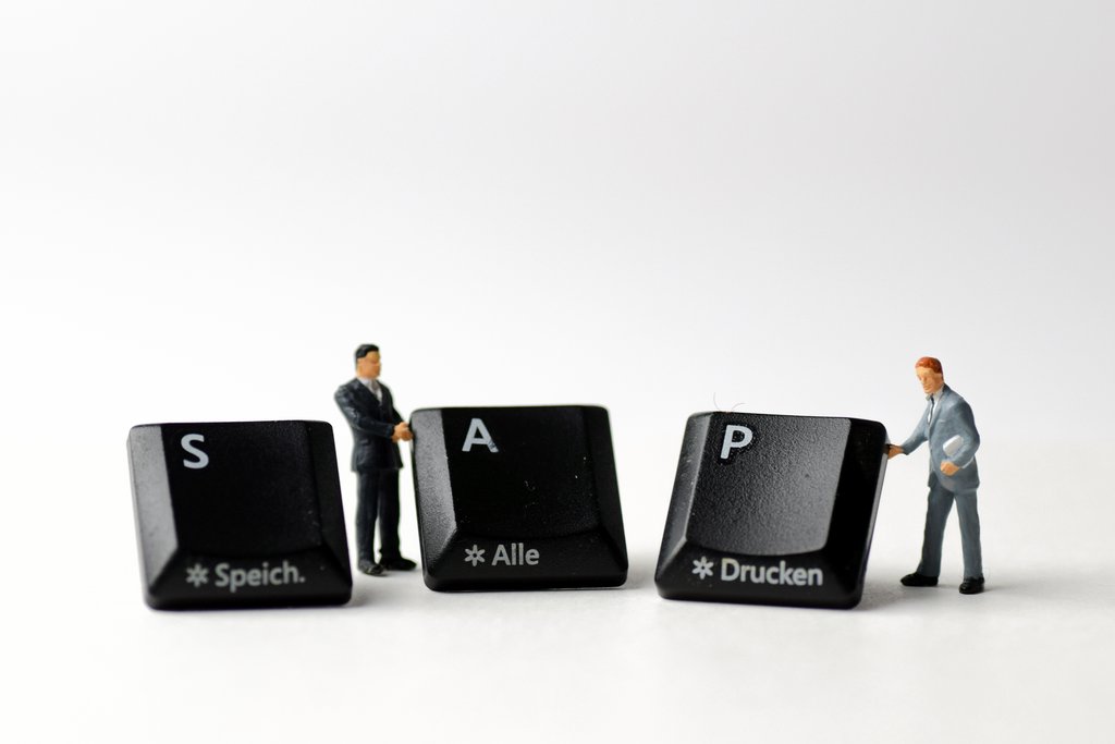 Zwei Minifiguren zeigen Tastaturtasten, die das Wort SAP ergeben und für das SAP-Know-how der sollistico stehen.